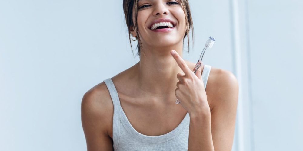 Shot,Of,Pretty,Young,Woman,Brushing,Her,Teeth,While,Looking cosmetic dentist near auburn
