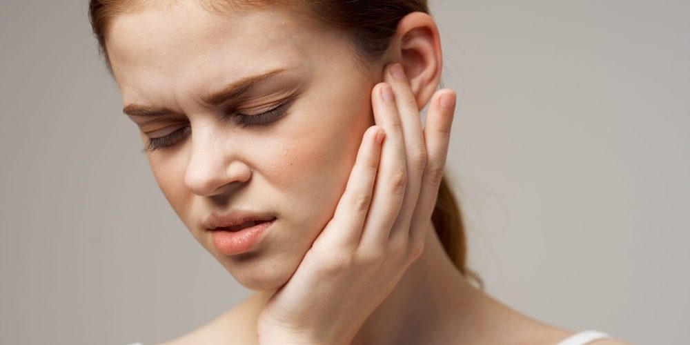 Woman,Touches,Face,With,Hand,Problems,With,Oral,Cavity toothache and earache