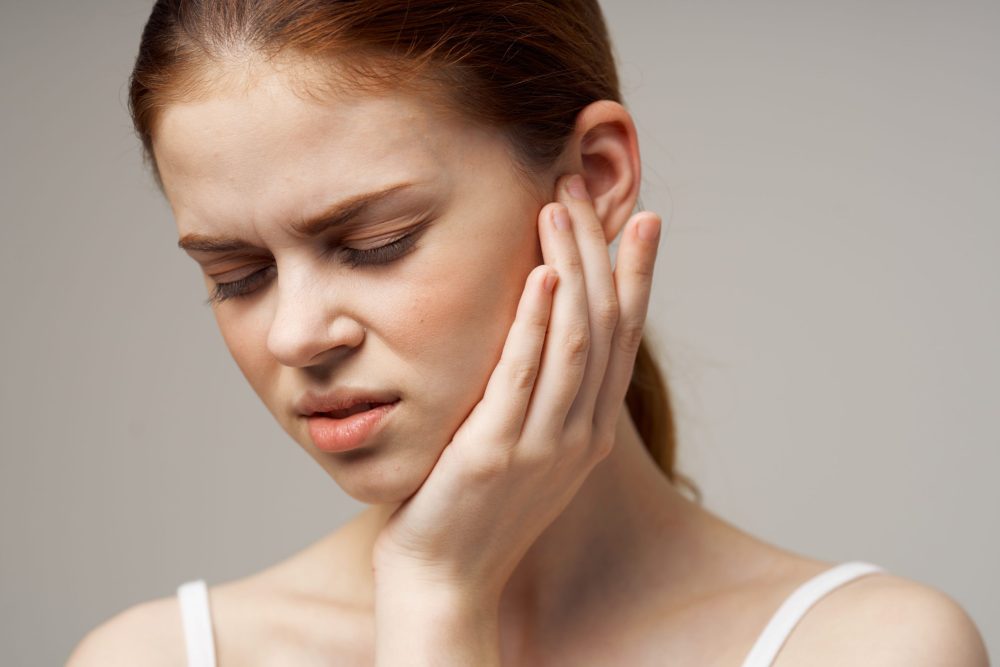 Woman,Touches,Face,With,Hand,Problems,With,Oral,Cavity toothache and earache
