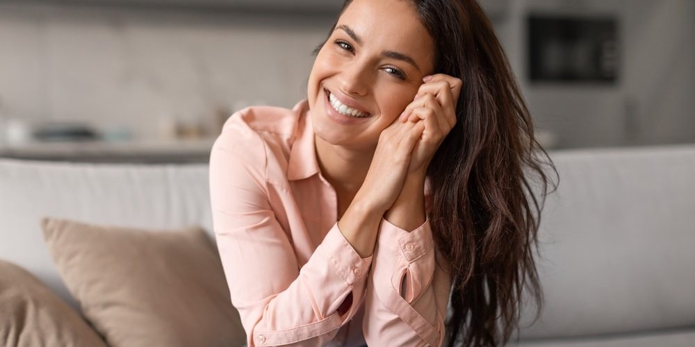 Radiant,Woman,With,Contagious,Smile,Poses,Playfully,,Hands,Gently,Cradling
