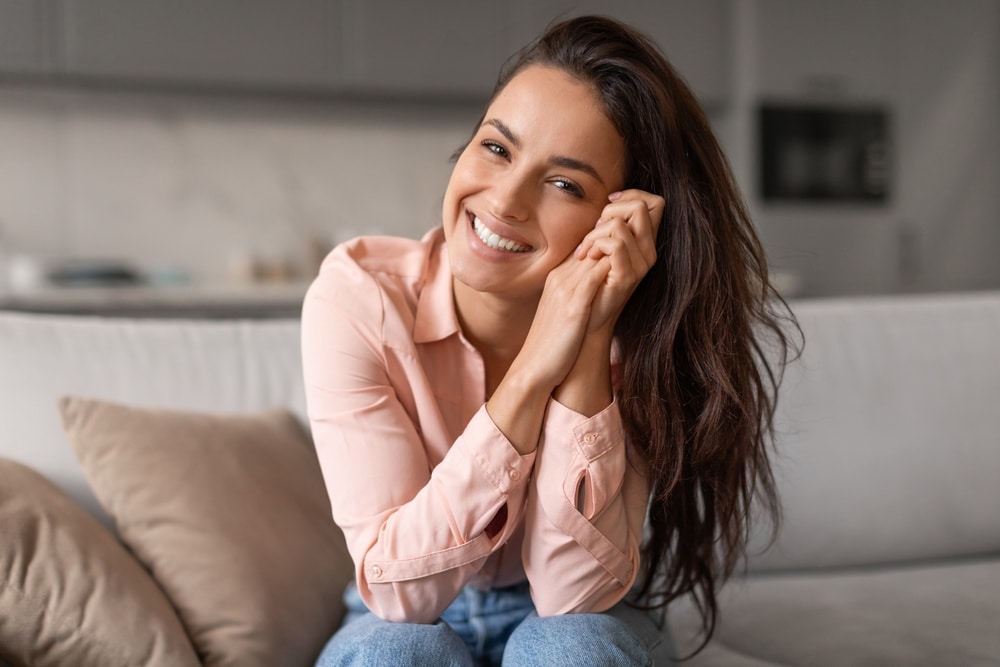 Radiant,Woman,With,Contagious,Smile,Poses,Playfully,,Hands,Gently,Cradling